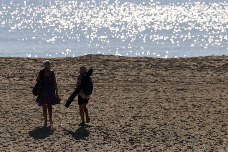 Dos personas se dirigen a la playa de El Saler, en Valencia, este miércoles. EFE/Kai Försterling

