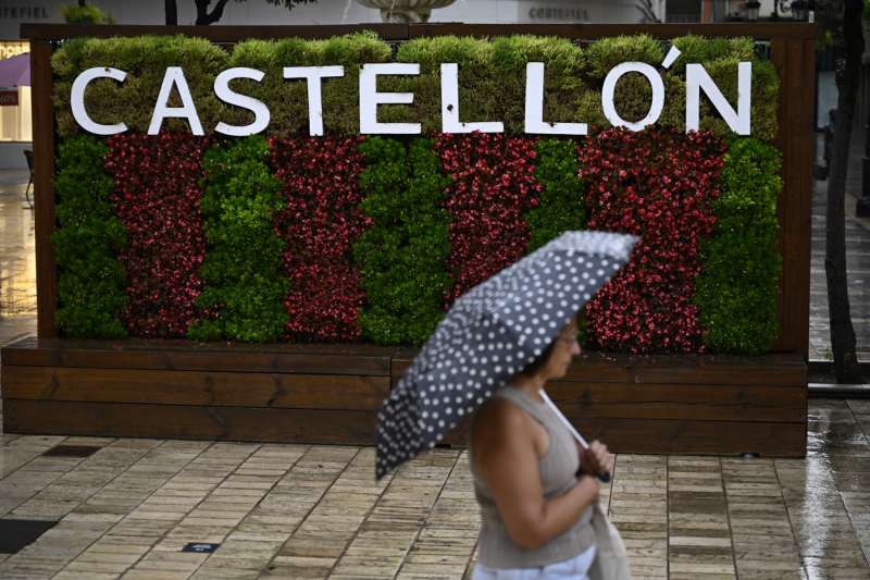 Una mujer cruza una calle de la ciudad de Castellón bajo una intensa lluvia. EFE/Andreu Esteban/Archivo

