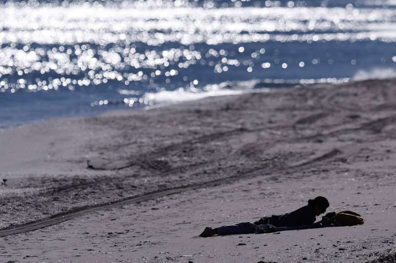 Una mujer descansa sobre la arena este sábado por la playa del Marenyet de Cullera. Archivo/ EFE/ Kai Försterling
