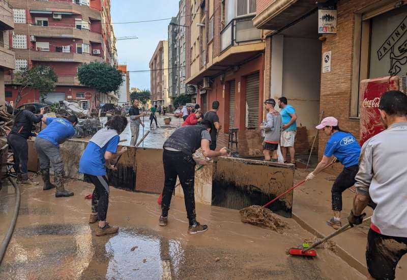 Voluntarios de Ford quitando barro en una población afectada por la dana, en una imagen facilitada a EFE.
