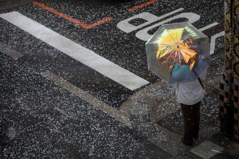 Una persona se protege del granizo con un paraguas este viernes en la ciudad de Valéncia. EFE/Biel Aliño/Archivo
