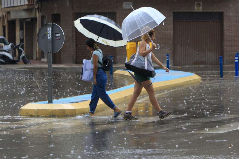 Dos personas cruzan una calle bajo la lluvia en una imagen de archivo. EFE/Morell/&Archivo
